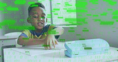 Smiling schoolchild coding with tablet in classroom showing green binary data overlay