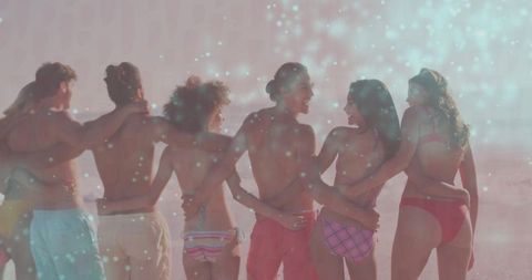Friends celebrating together on scenic beach at sunset