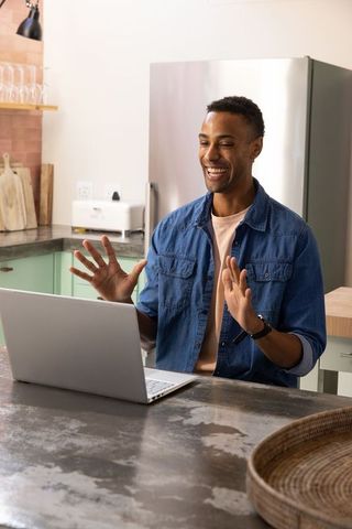 African-american professional video conferencing from contemporary kitchen