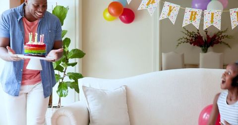 Father Presenting Birthday Cake to Excited Child at Home Celebration