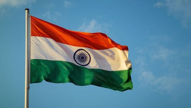 Indian national flag waving against blue sky