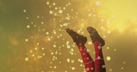 Athlete Raising Legs in Red Soccer Socks and Black Cleats with Golden Bokeh Glow