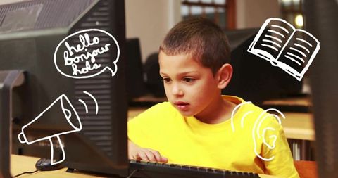 Focused schoolboy working at computer in classroom with hand-drawn education doodles