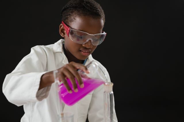 Schoolgirl doing a chemical experiment against black background - Download Free Stock Photos Pikwizard.com