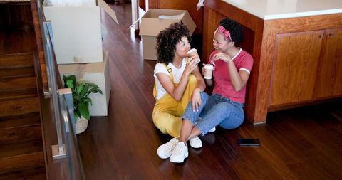 Lesbian Couple Smiling While Unpacking in New Home