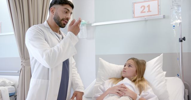 Diverse male doctor showing girl patient in hospital bed how to use asthma inhaler - Download Free Stock Photos Pikwizard.com