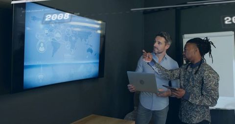 Colleagues analyzing digital global network on office display