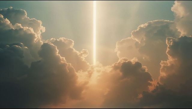 Vertical light beam cutting through cloudscape at sunrise