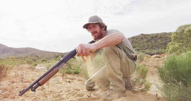 Man Holding Rifle in Desert Landscape - Download Free Stock Images Pikwizard.com