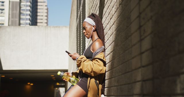 Fit Woman Taking Break from Workout Holding Water Bottle and Smartphone - Download Free Stock Images Pikwizard.com