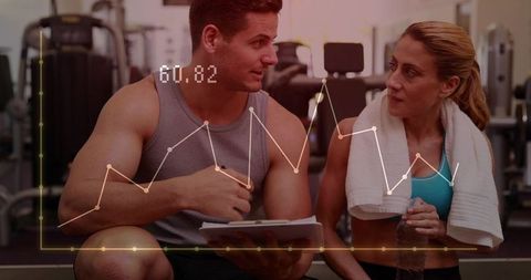 Female trainer coaching male client on gym floor with real-time fitness data overlay