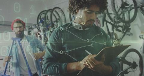 Young mechanics in bike repair shop analyzing data trends