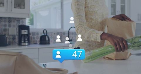 Unpacking groceries on sunlit kitchen island holding celery with social follower notification