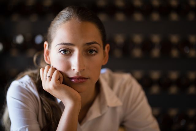 Young woman sitting in a bar, looking unhappy and thoughtful. Ideal for use in articles or advertisements about emotions, mental health, loneliness, or personal reflection. Can also be used in blogs or social media posts discussing life challenges or introspection.