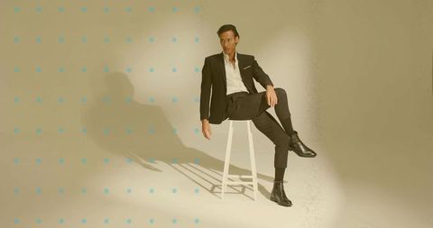 Elegant asian model posing in black suit against minimalist backdrop