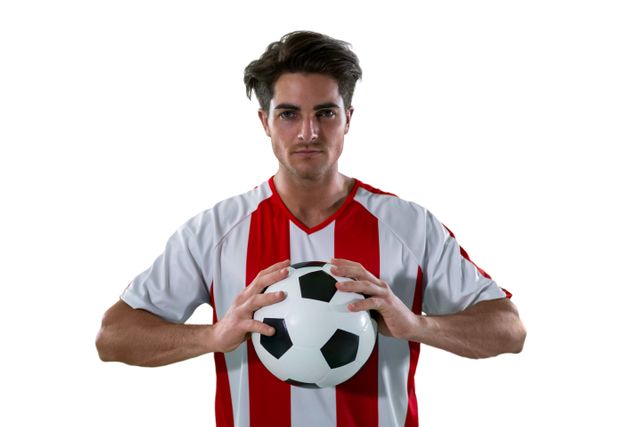 This image features a football player with a focused expression holding a football against a white background. He is wearing a red and white jersey. Ideal for use in sports-related articles, blogs about soccer, promotional materials for football teams, and advertisements for sports equipment.