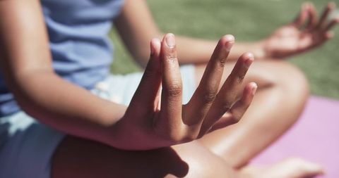 African American Teen Meditating Outdoors on Pink Yoga Mat Practicing Mindfulness in Park