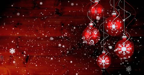 Festive red christmas baubles with falling snowflakes
