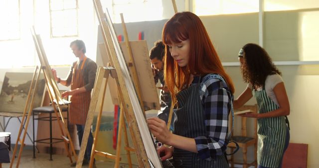 A group of people are engaged in an art class, each focusing on their own easels and canvas. This image can be used to illustrate stories or promotional materials related to art education, creativity workshops, or community art programs. Perfect for use in educational websites, art supply promotional content, or brochures for art schools.