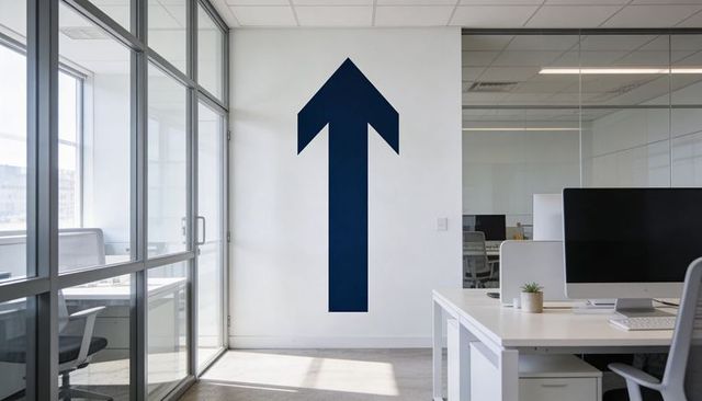 Navy upward arrow mural in minimalist glass office, directional wall accent for productivity