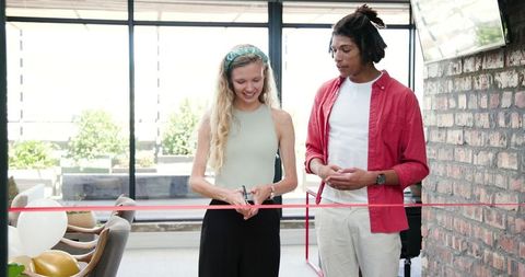Smiling Colleagues Celebrating with Ribbon and Balloons in Office Event
