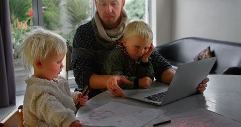 Caucasian Father and Children Engaging with Laptop Indoors
