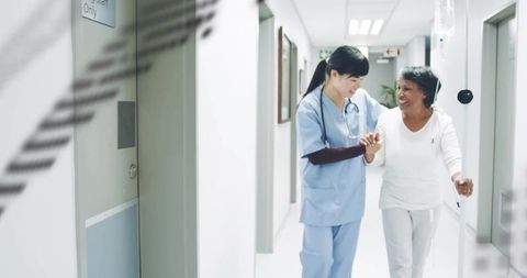 Nurse Supporting Senior Patient Walking Hospital Hallway with IV Pole and Stethoscope