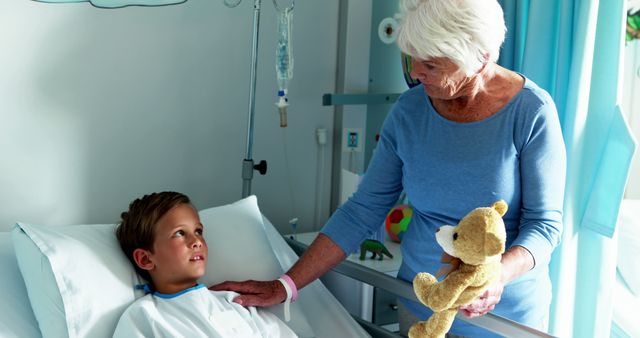 Elderly Woman Comforting Young Boy in Hospital Bed with Teddy Bear - Download Free Stock Images Pikwizard.com