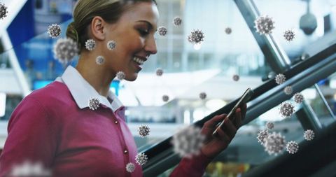 Woman at Airport Using Smartphone Amid Floating Virus Particles