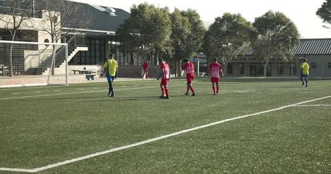 Teammates in Action on Grass Soccer Field During Match