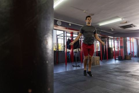 Man jumping rope in gym performing high-intensity cardio and functional workout