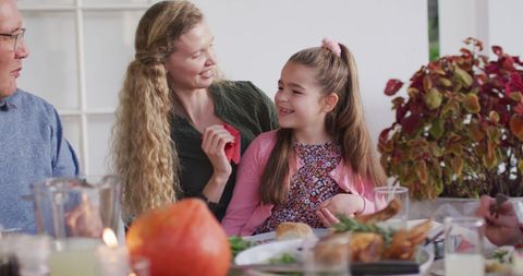 Image of happy caucasian mother cleaning daughter's face at family dinner table - Download Free Stock Photos Pikwizard.com