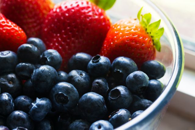 Bright and appetizing berries in a glass bowl, perfect for healthy eating, diet, summer recipes, fruit salads, and natural ingredients.