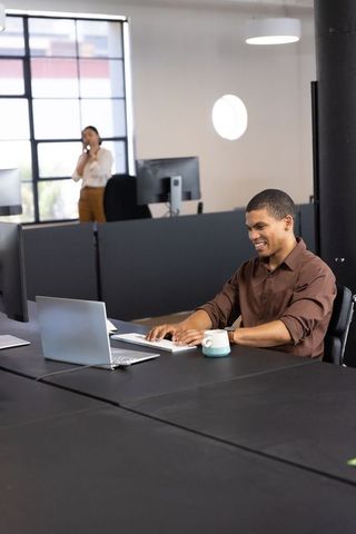 Professional Businessman Working on Laptop in Modern Open-Plan Office