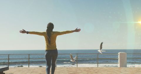 Woman Embracing Freedom by the Sea on Sunny Day