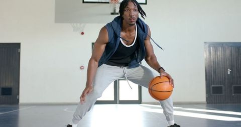 Active Male Athlete Dribbling Basketball on Indoor Court for Fitness Training