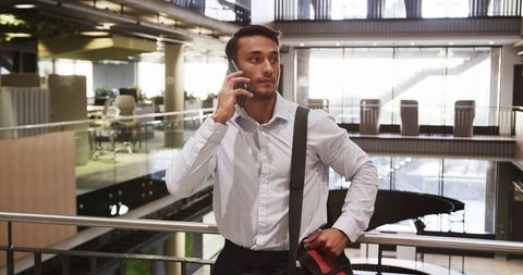 Business Professional Talking on Smartphone in Modern Atrium