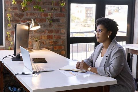 Professional Woman Taking Notes in Modern Office Desk Setup