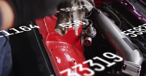 Mechanic tuning high-performance engine bay with glowing red inner fender and data overlay
