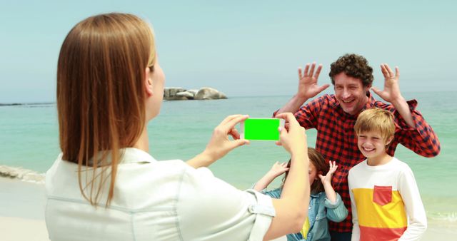 Family members on sandy beach posing for camera. Children and parents smiling and making funny gestures near ocean. Perfect for parenting, travel, and happy lifestyle concepts, as well as family vacation promotions.