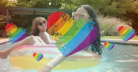 Floating women on pool inflatables showing rainbow heart pride overlay summer relaxation