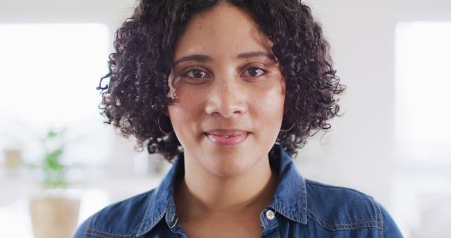 Portrait of biracial woman looking to camera and smiling, in slow motion. Emotions and lifestyle concept.