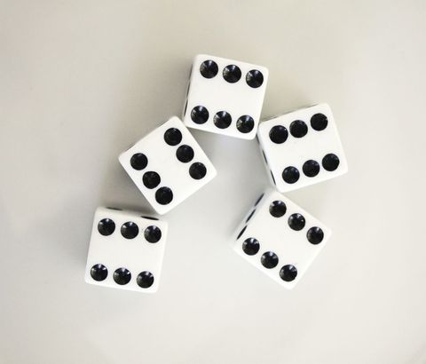 Group of dice arranged on white surface displaying number five