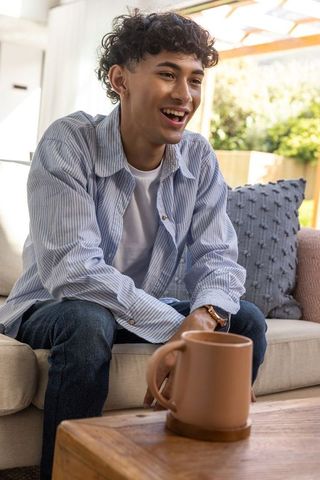 Young Man Enjoying Relaxing Moment at Home with Coffee Mug