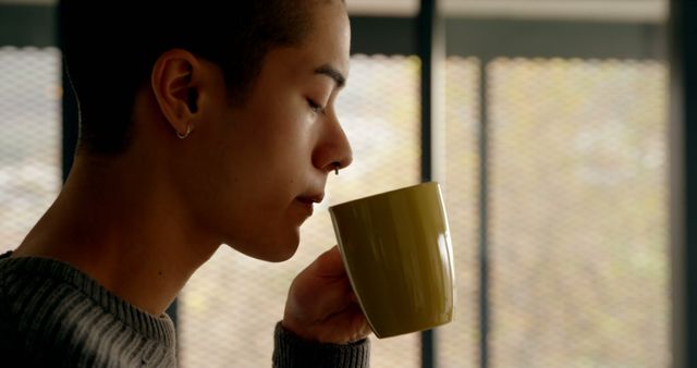 Person Sipping Coffee Near Window in Relaxed Contemplation - Download Free Stock Images Pikwizard.com