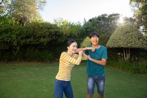Playful Couple Arm Wrestling in Sunny Backyard