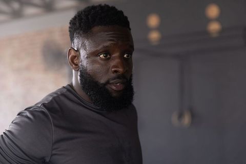 African american man catching breath sweating after intense gym workout