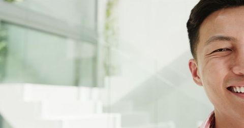Cheerful Young Asian Man Smiling Indoors with Bright Atmosphere - Download Free Stock Images Pikwizard.com