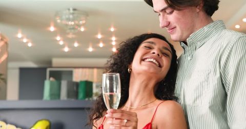 Happy Couple Celebrating with Champagne in Living Room