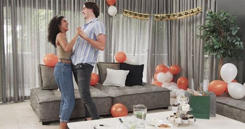 Happy Couple Dancing at Birthday Party in Decorated Living Room